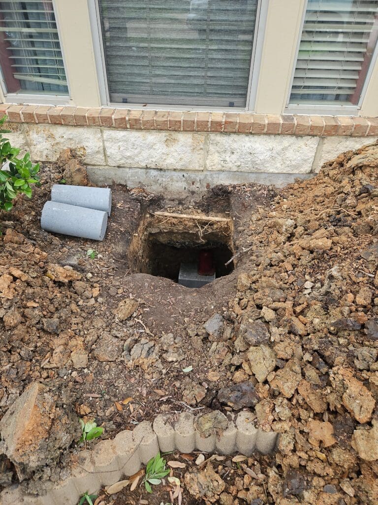 Exterior holes excavated for under-slab concrete repair and foundation leveling in Pearland, Texas