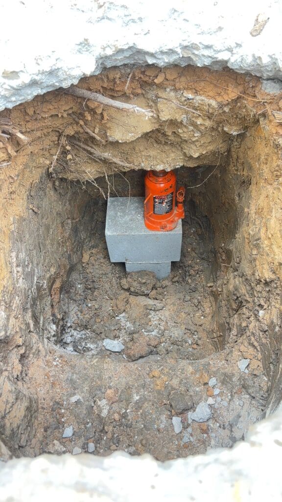 House being jacked up for home leveling using concrete blocks in Pearland, Texas