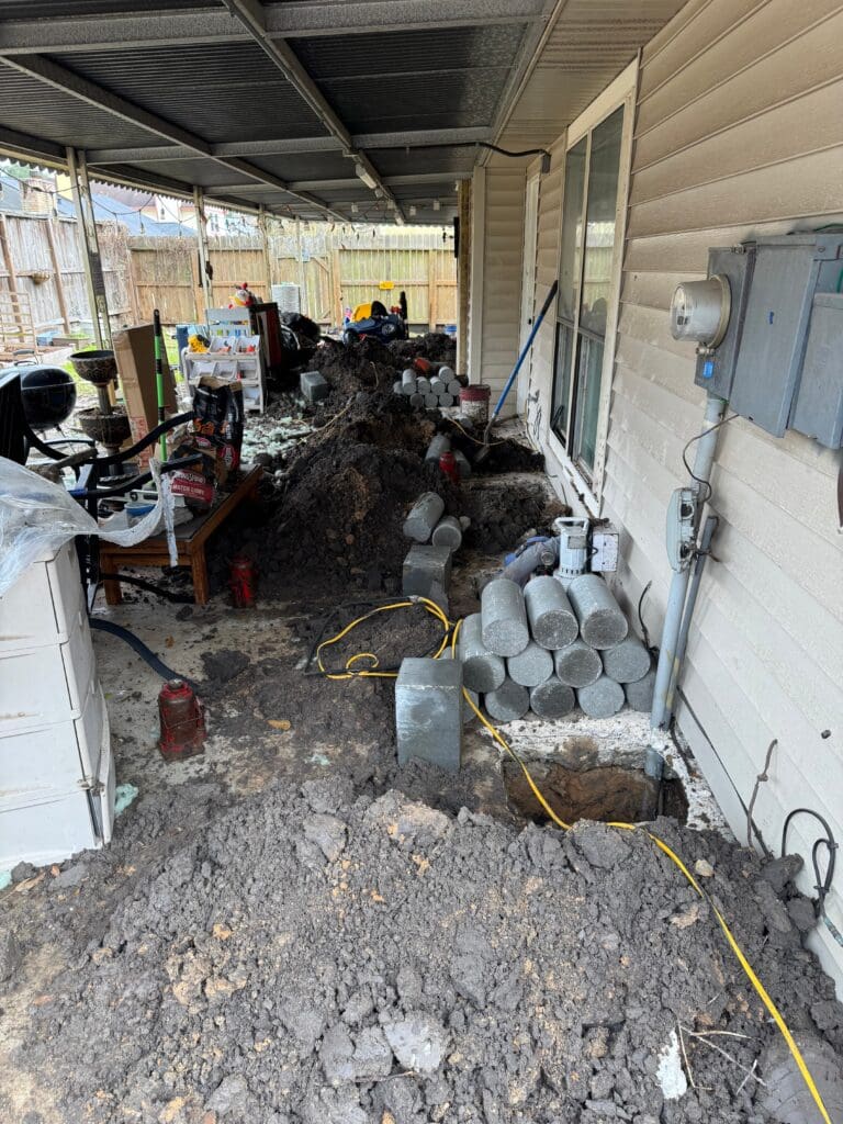 Exterior holes for pressed pilings by the best Pearland Foundation repair company